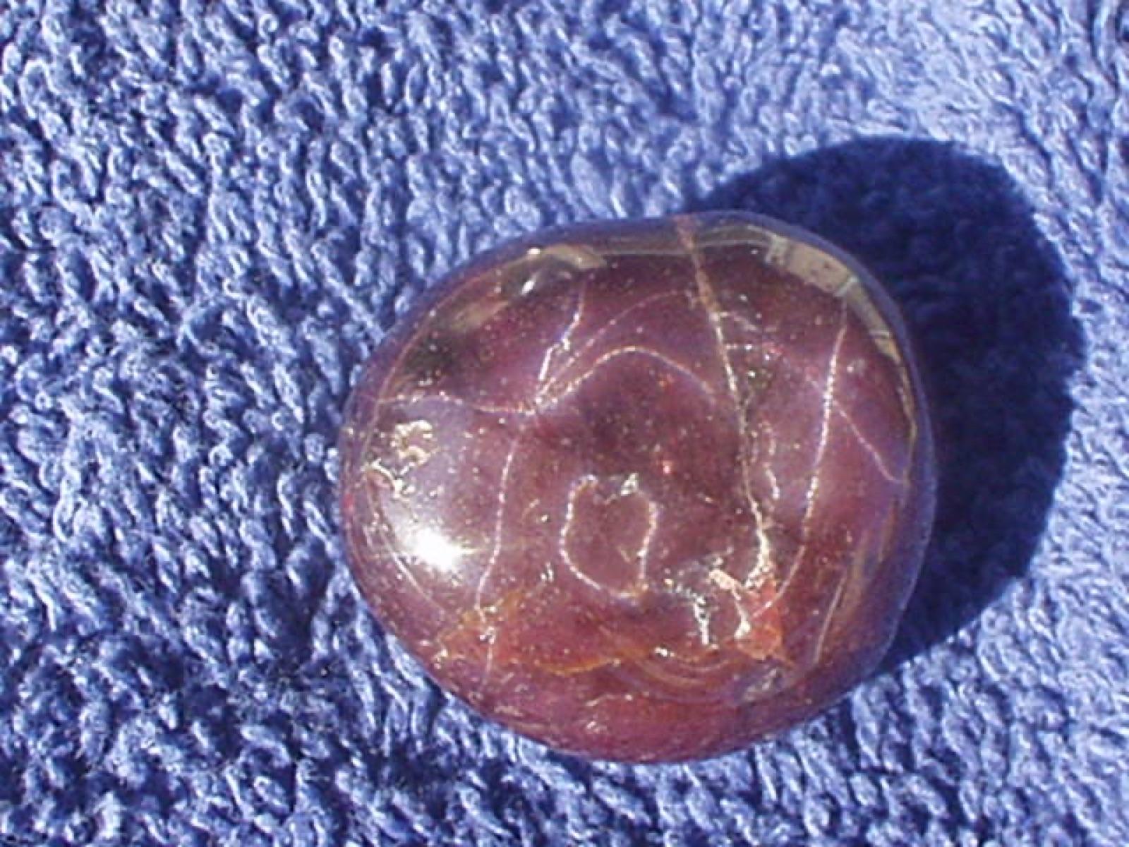 Polished star garnet cabochon in the deep purplish red typical of Emerald Creek
