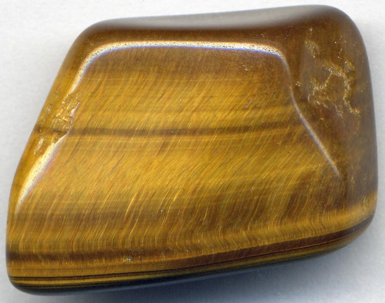 Polished tiger's eye showing the silky chatoyant band sweeping across the fibres
