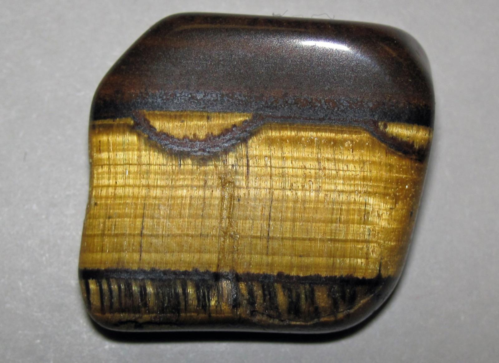 Tiger's eye slab with golden chatoyant layers against dark hematite bands