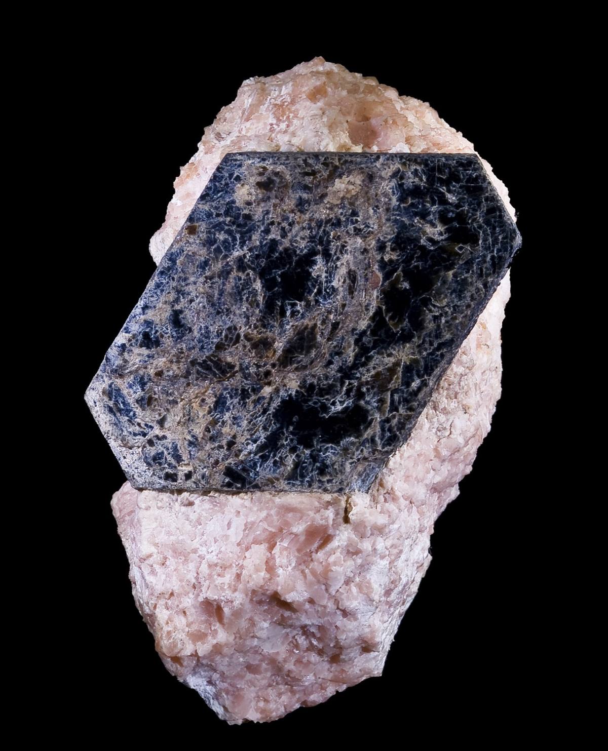 Black pseudohexagonal biotite crystal in pink calcite, Quebec