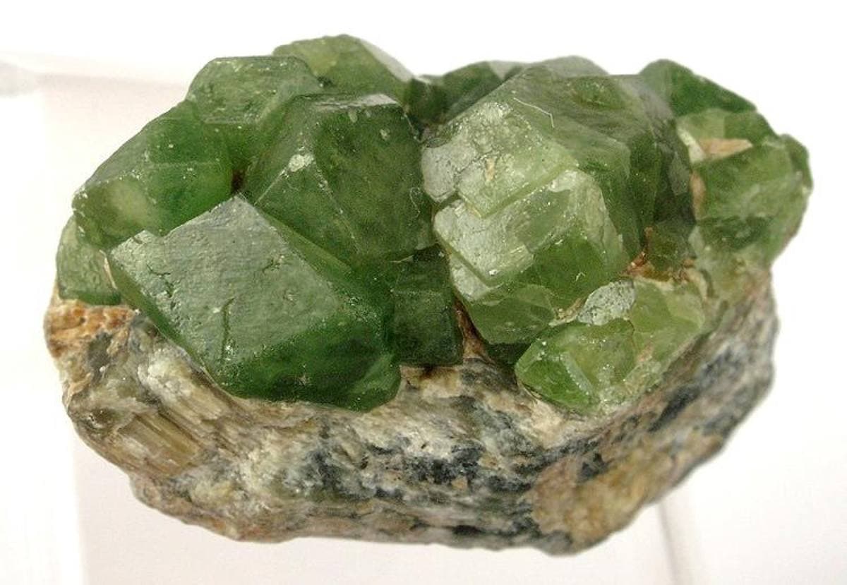 Green demantoid andradite dodecahedra on matrix