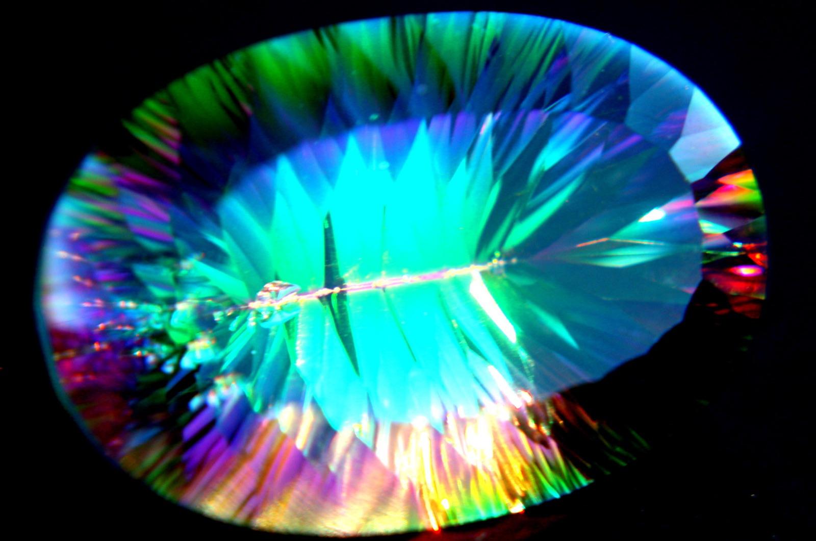 Loose oval mystic topaz showing its rainbow surface coating