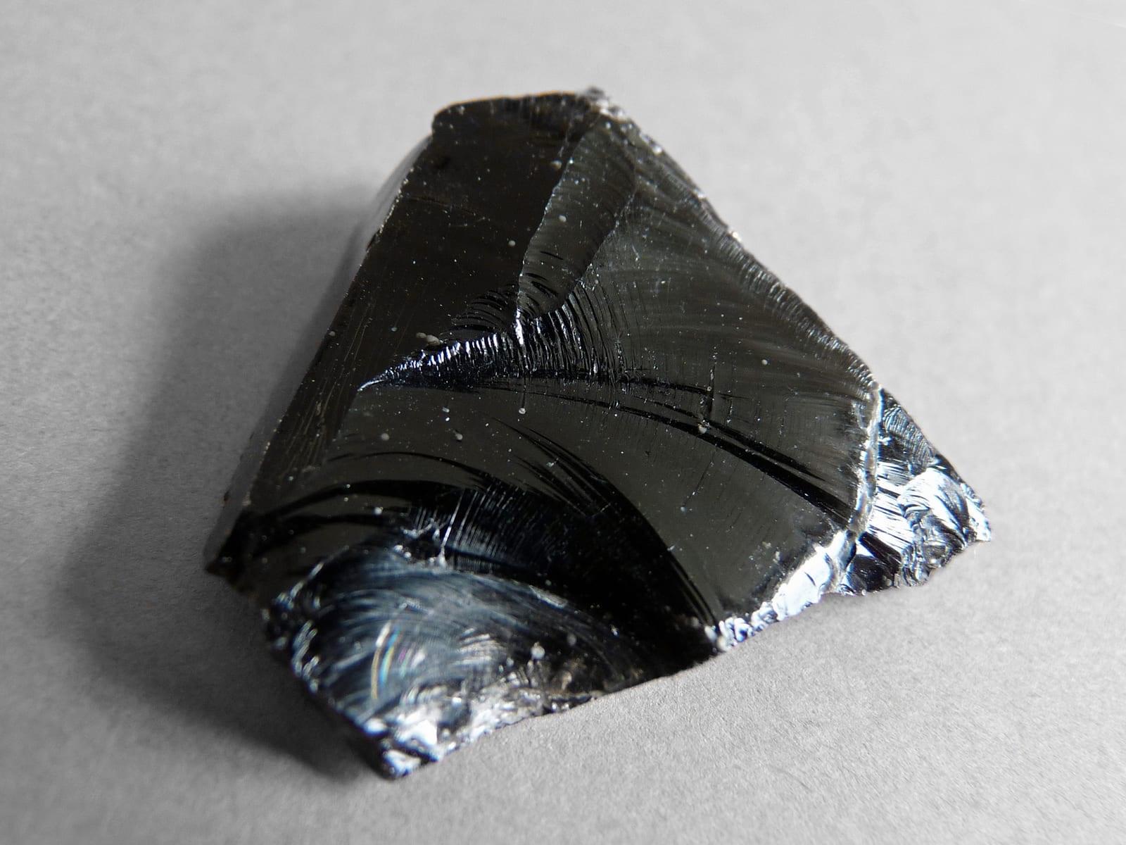 Obsidian showing the bright conchoidal fracture and glassy black break that identify it