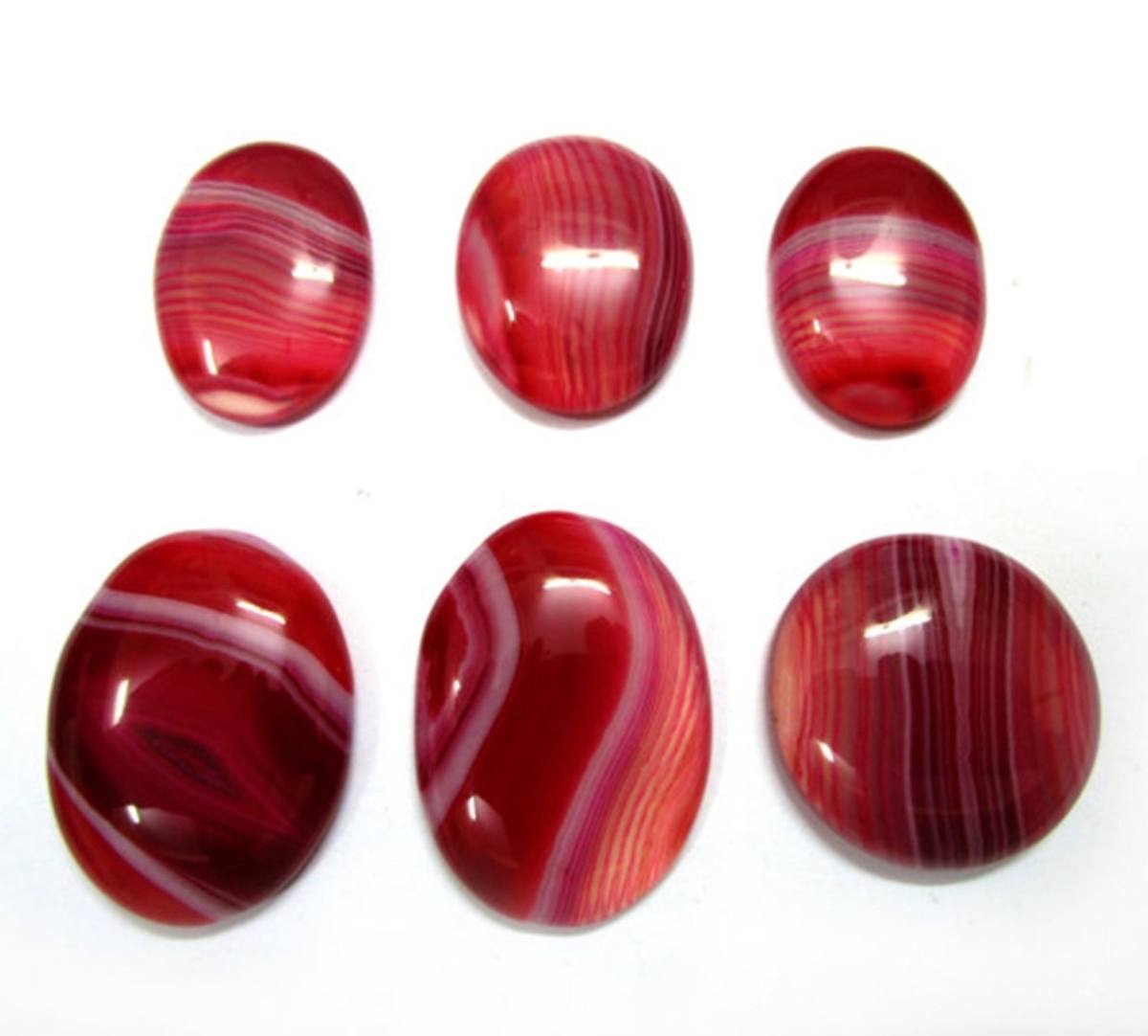 Red and white banded onyx cabochons showing parallel banding