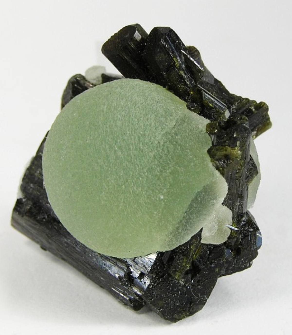 Prehnite sphere framed by dark green epidote blades