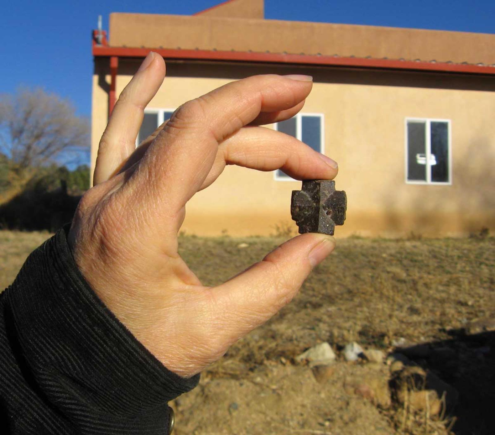 Staurolite cross held in the hand, near Pilar, New Mexico