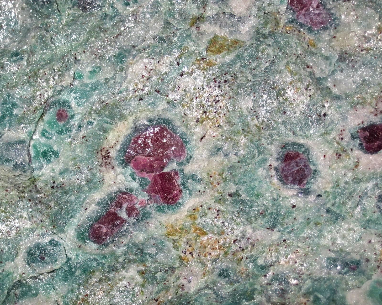 Red ruby crystals (corundum) in matrix, like the small rubies shed from vein exposures into the Little Tallapoosa River gravels