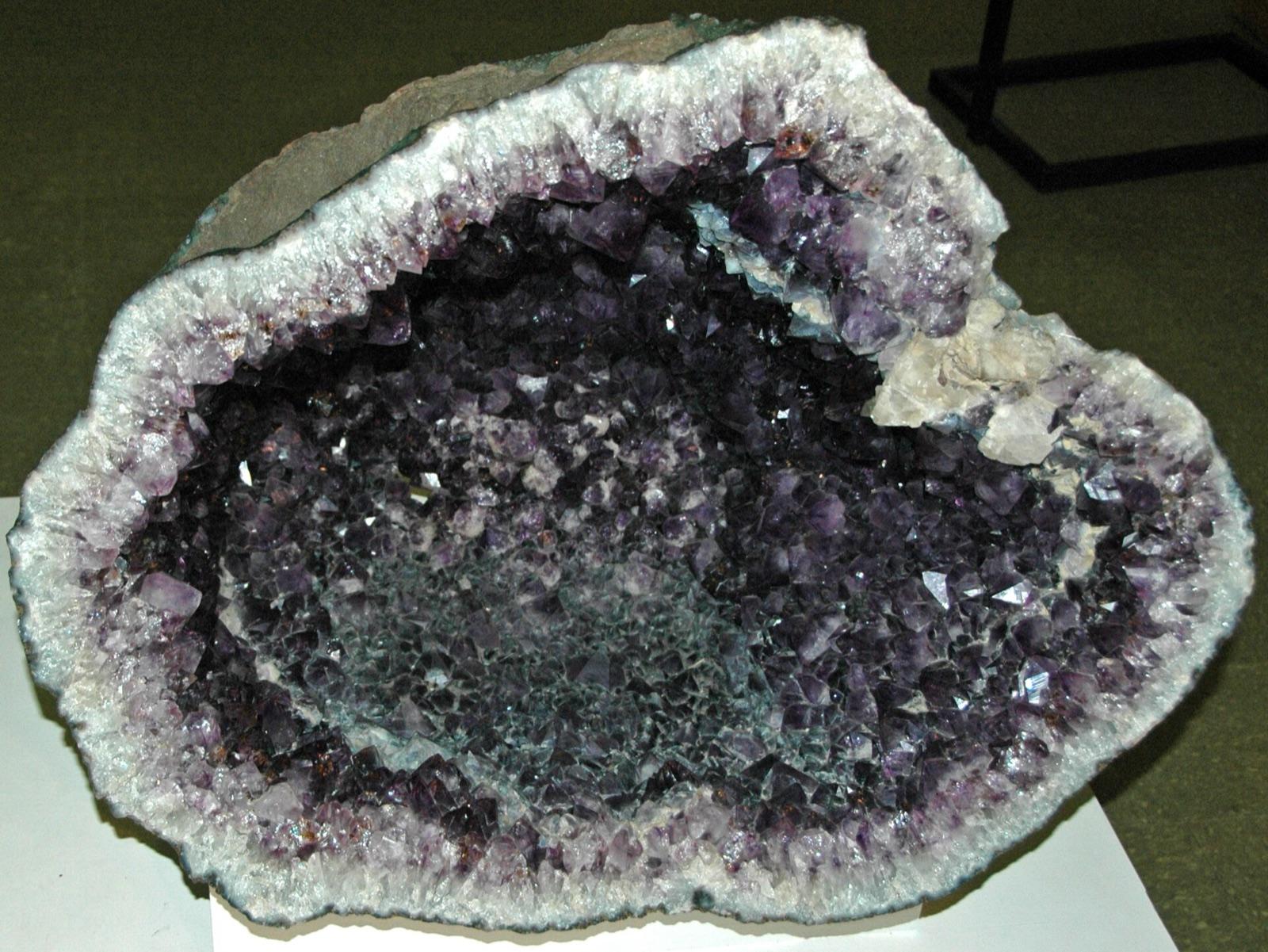 An amethyst geode lined with purple quartz crystals and a white chalcedony rim, the kind of crystal-lined geode found in the northern Black Hills gravels